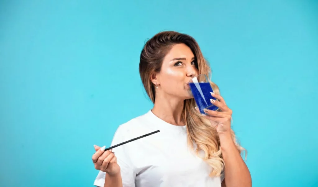 Femme buvant phycocyanine liquide